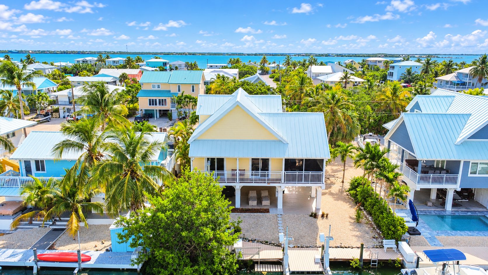 A resort with multiple buildings, a swimming pool, and a view of the ocean.