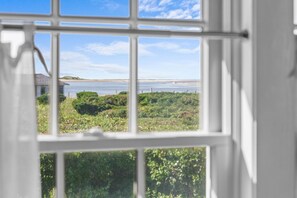 A view through a window with a clear sky and a distant landscape. - The Winthrop - Beachfront Cape Cottage with private beach (Barnstable)