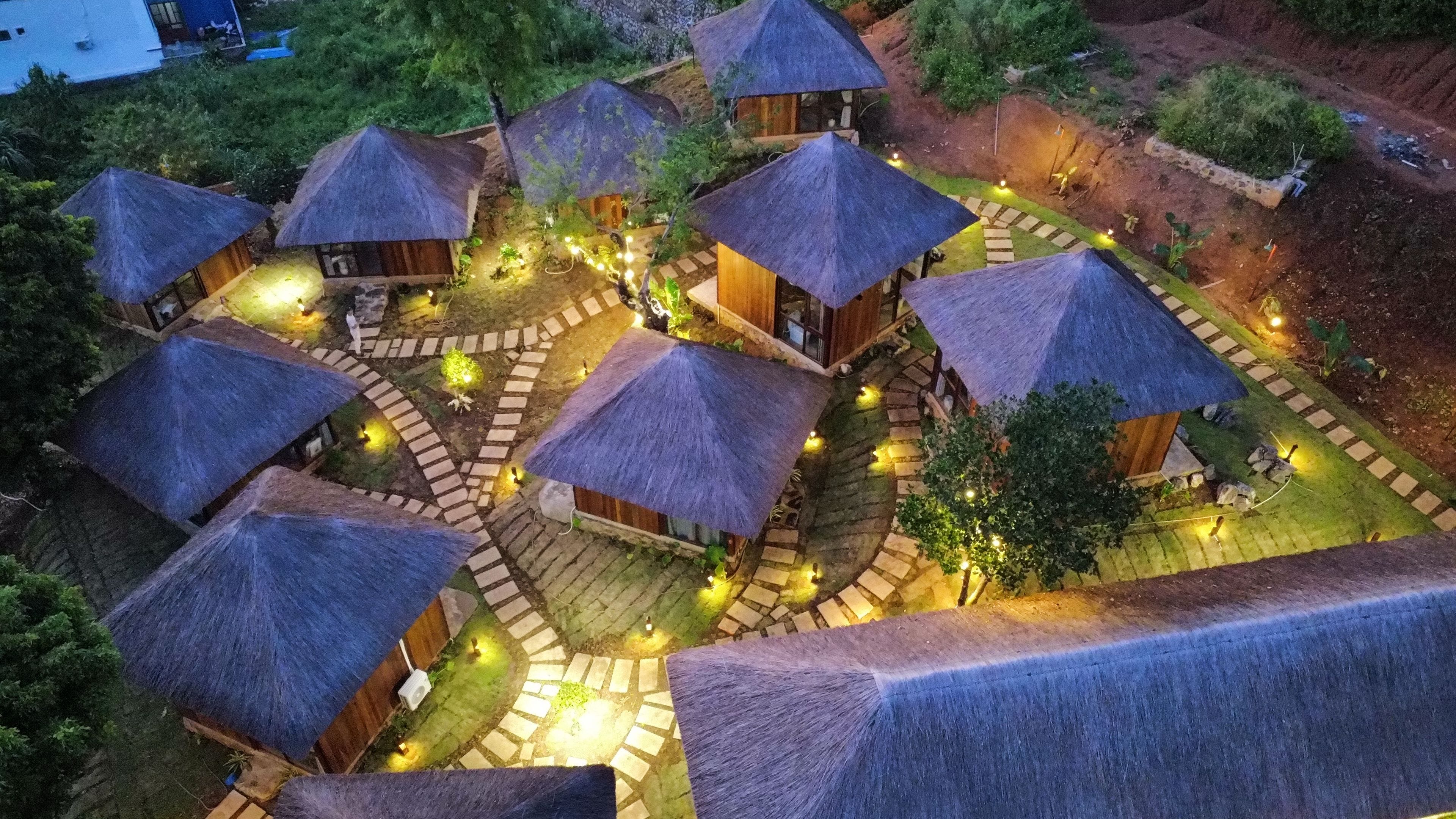 A series of thatched-roof huts arranged in a circular pattern with pathways connecting them.