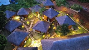 A series of thatched-roof huts arranged in a circular pattern with pathways connecting them.