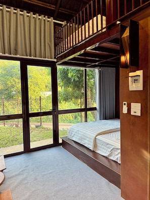 A room with a bed, a window with curtains, a door with a lock, and a small table.