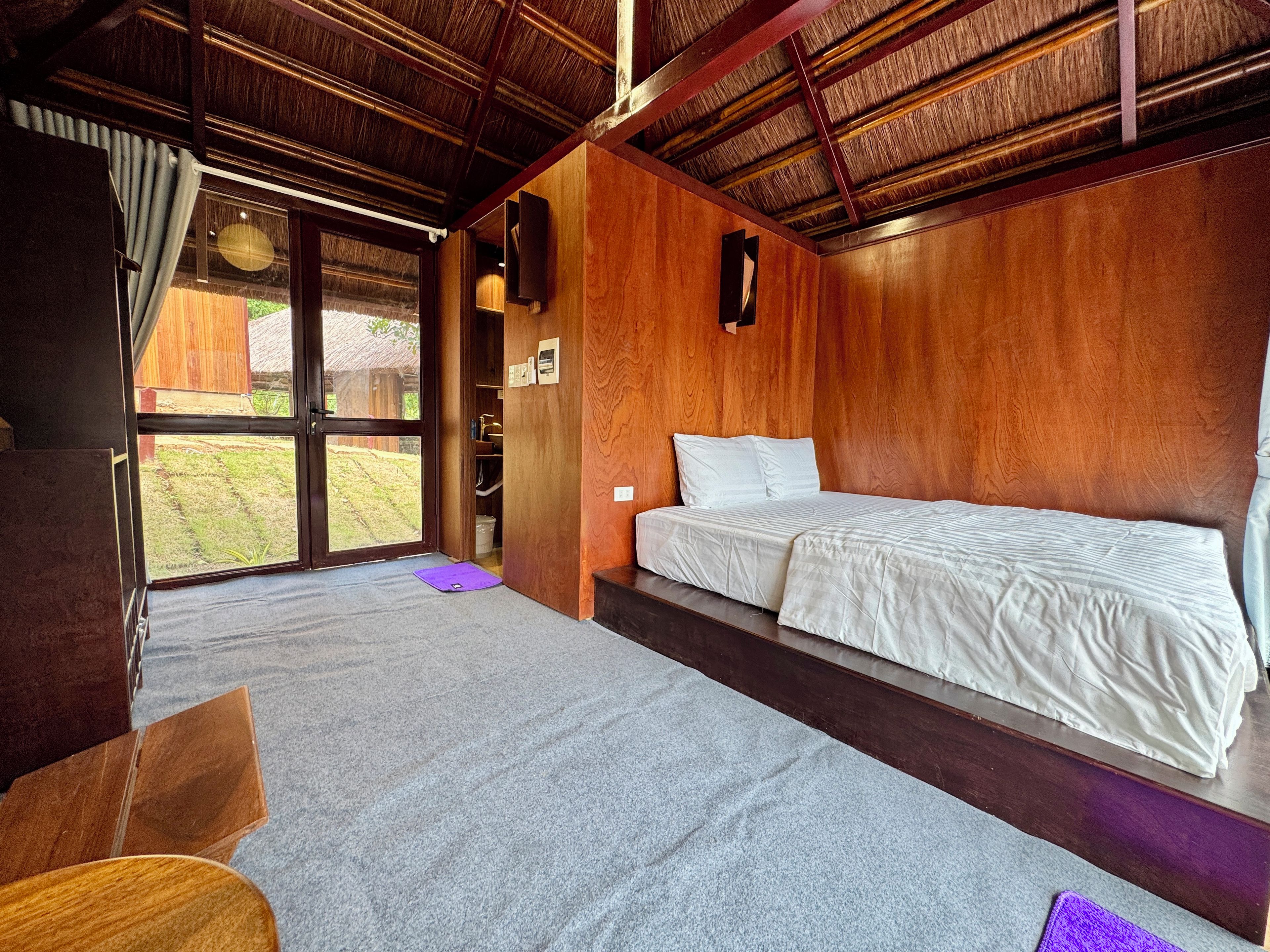 A room with a bed, a desk, and a window.