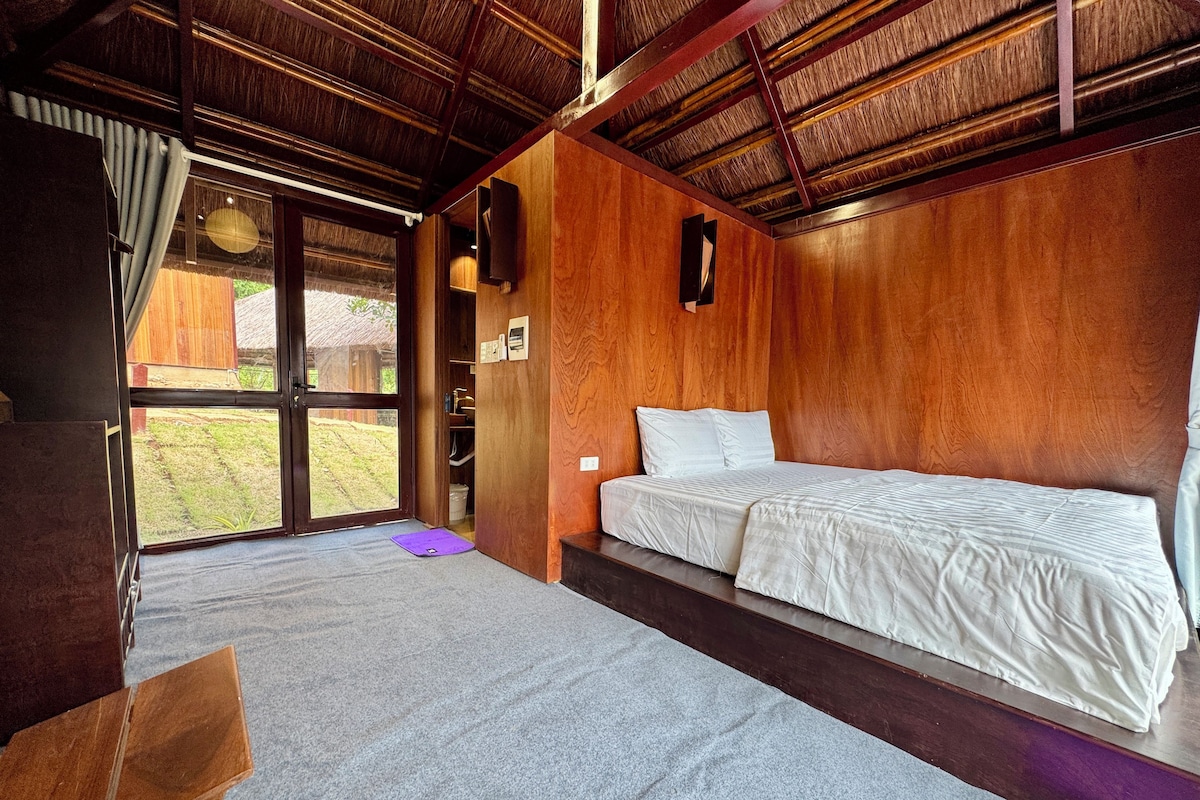 Een kamer met een bed, een bureau en een raam.