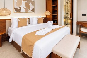 A neatly made bed with a white and beige bedspread, a wooden headboard, and a bedside table with a lamp. - New 3BR Villa + Pv Pool | Uluwatu Promo Rate unitC (Badung Regency)