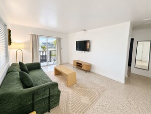 Bright living room with balcony access, smart TV, and cozy seating - 2BR Near Wynwood | Heated Pool + Private Balcony (Miami)