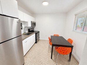 Bright modern kitchen with stainless appliances and dining for four - 2BR Near Wynwood | Heated Pool + Private Balcony (Miami)
