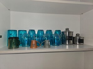 A shelf with various glass containers and metal tins. - Beautiful 2-bedroom house with AC in Discovery Bay (Discovery Bay)