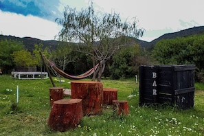 Un hamac, des souches d’arbres et une structure noire ornée de lettres.
