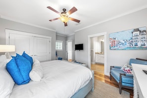 A bedroom with a bed, a ceiling fan, a TV, and a painting on the wall. - Salty Seagull - Private Beach Access, 4 bikes! (Seacrest)