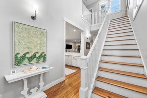 A staircase with wooden steps and white railings leading to an upper level. - Salty Seagull - Private Beach Access, 4 bikes! (Seacrest)