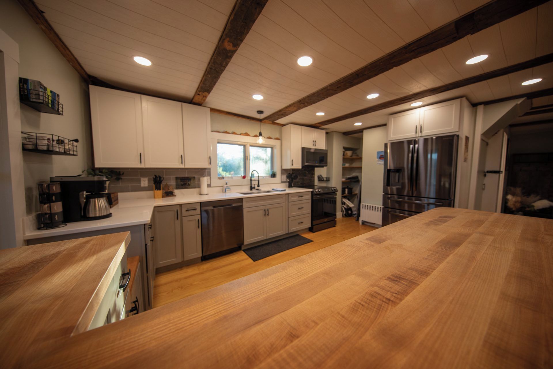 A modern kitchen with wooden countertops, stainless steel appliances, and a large island.