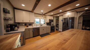 A modern kitchen with wooden countertops, stainless steel appliances, and a large island.