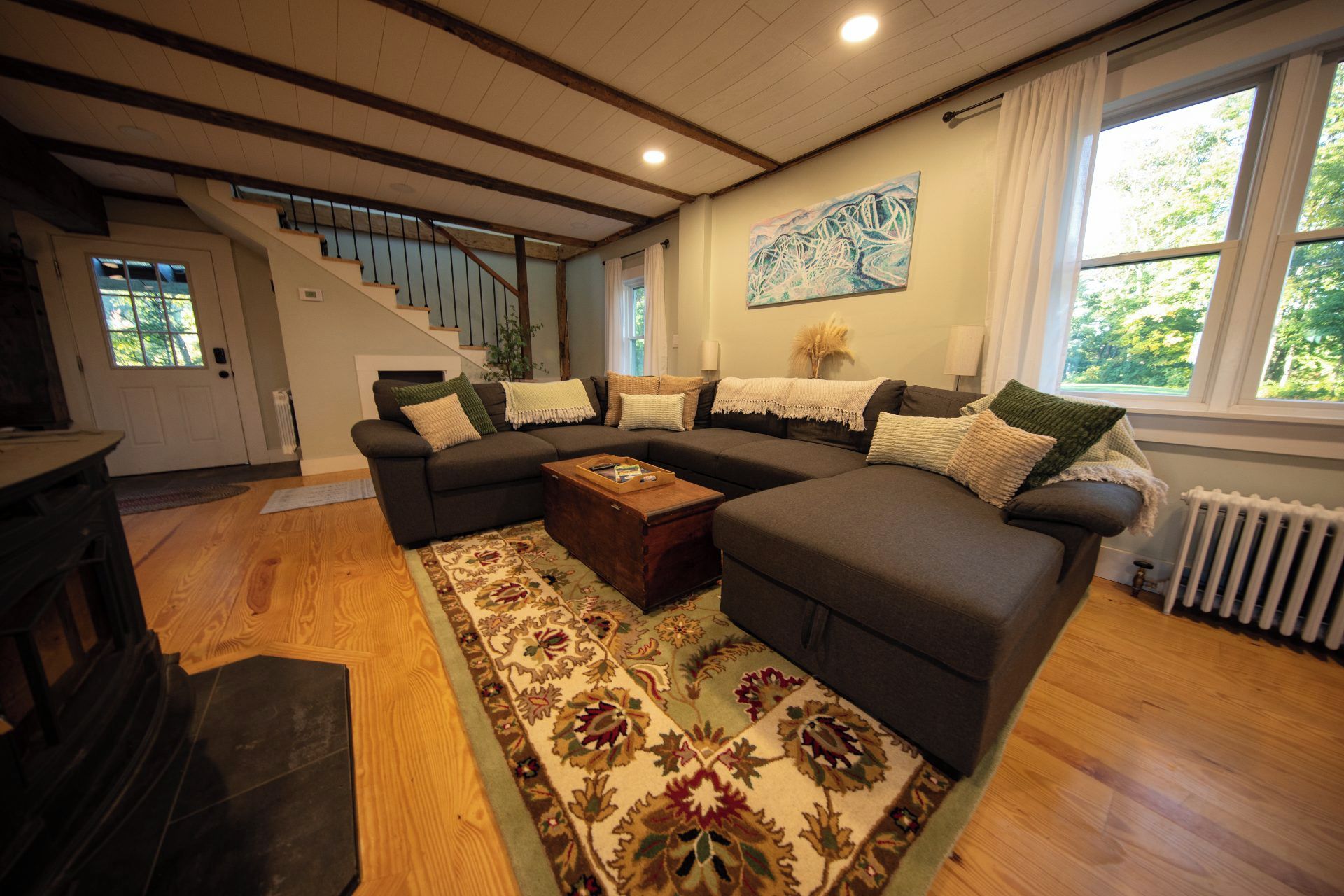 A living room with a sectional sofa, a coffee table, and a patterned rug.