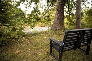 A park bench in a wooded area with trees and grass. - Farmhouse Escape w/Hot Tub, EV Charger, Ski Bar - 10 mins to Sunday River (Rumford)
