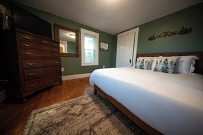 Un dormitorio con cama, cómoda y ventana.