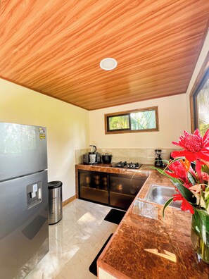 A kitchen with a stainless steel refrigerator, a coffee maker, and a sink.