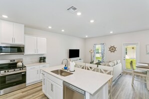 A modern kitchen with white cabinetry, a stainless steel sink, and a built-in dishwasher. - Pool & Playground - Newly Built 3BR Gulf Breeze Townhome Near The Zoo, Navarre Beach, and Pensacola (Gulf Breeze)