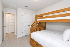 A bedroom with a bunk bed, a door, and a staircase. - Pool & Playground - Newly Built 3BR Gulf Breeze Townhome Near The Zoo, Navarre Beach, and Pensacola (Gulf Breeze)