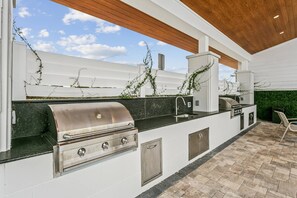 Eine Außenküche mit integriertem Grill, Spüle und Arbeitsplatte.