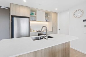 Eine moderne Küche mit Einbaukühlschrank, Spüle und Holzschränken.