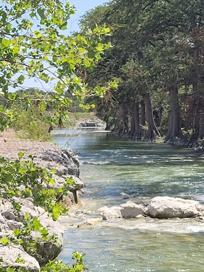 Een heldere rivier, omringd door rotsen en bomen.
