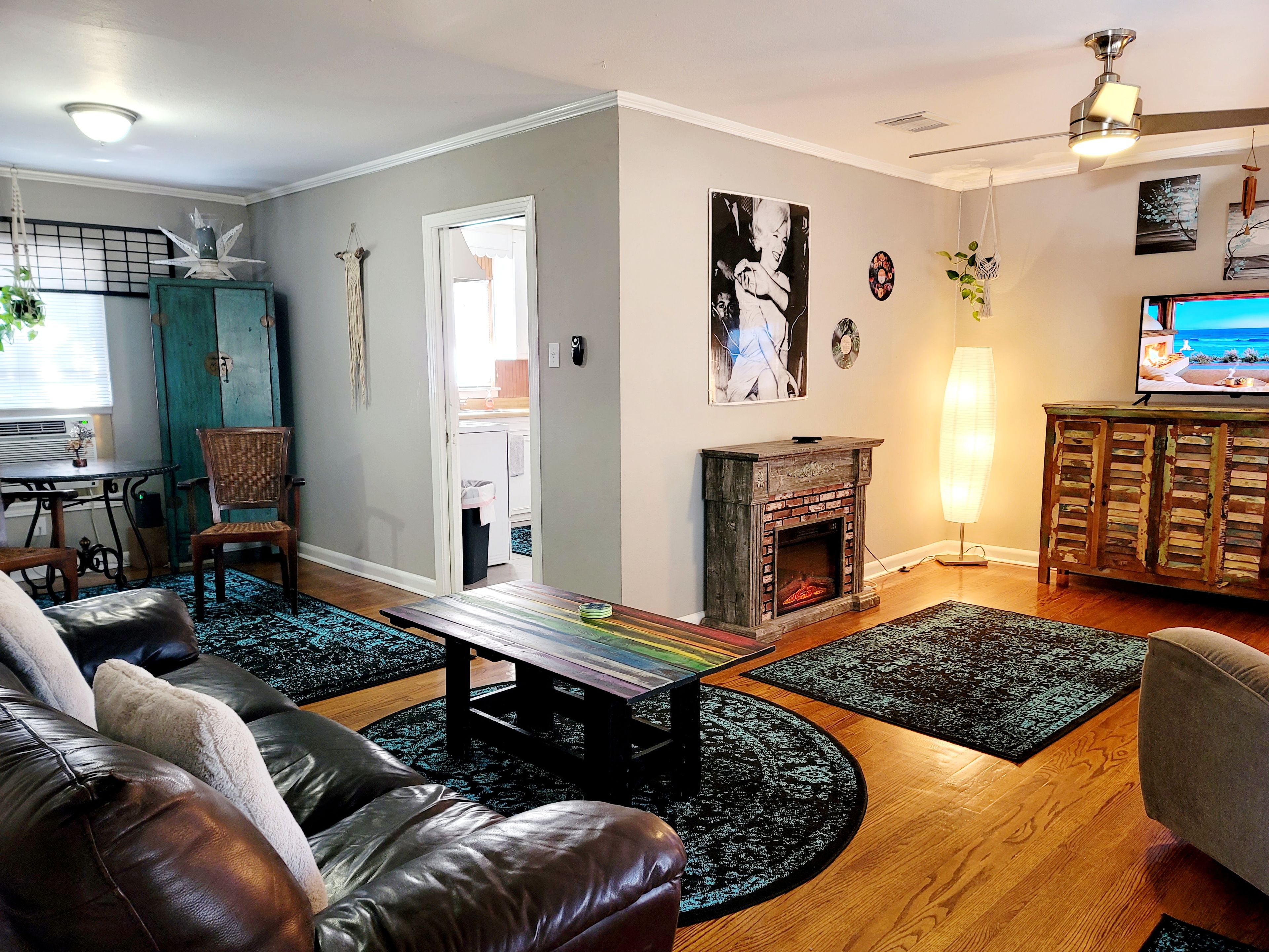 A living room with a fireplace, leather sofas, a coffee table, and a television.