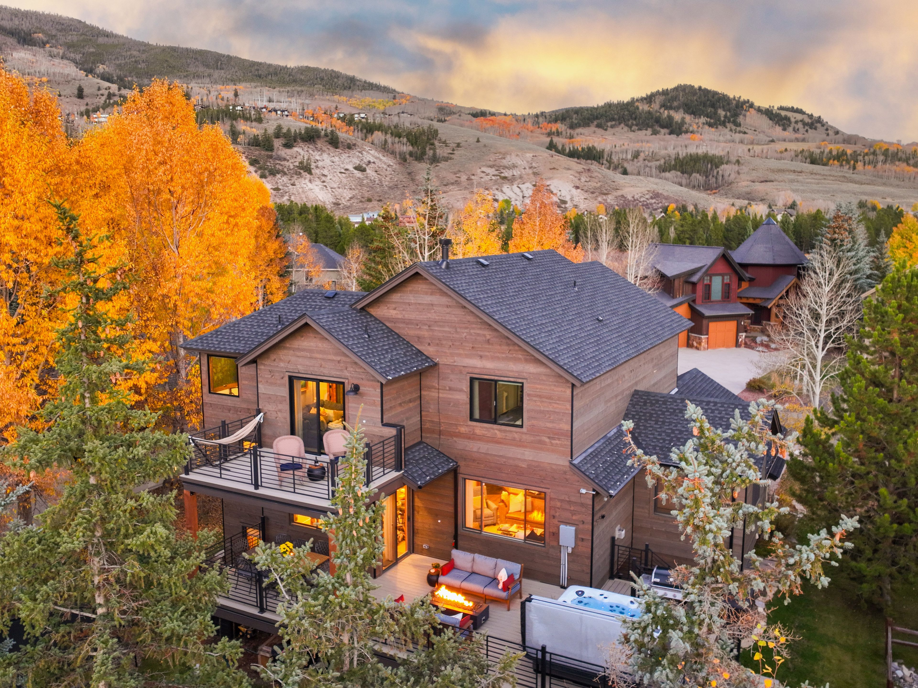 Une cabane en bois à deux étages, dotée d’un balcon, d’un jacuzzi et d’une terrasse.