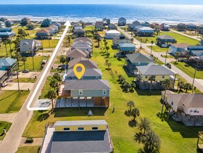 A coastal residential area with houses, a marked location, and a view of the ocean. - Ocean View | Inflatable Hot Tub | Arcade Game (Crystal Beach)