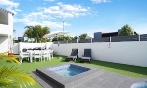 A pool area with a hot tub, lounge chairs, and a table with umbrellas. - Sunseeker Studio - Ground Floor Apt (Noosa Heads)