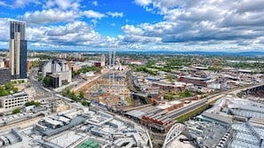 A cityscape with a mix of modern and older buildings, a large construction site, and a prominent Ferris wheel. - Skyline Rotunda City Apartment I Bullring (Birmingham)