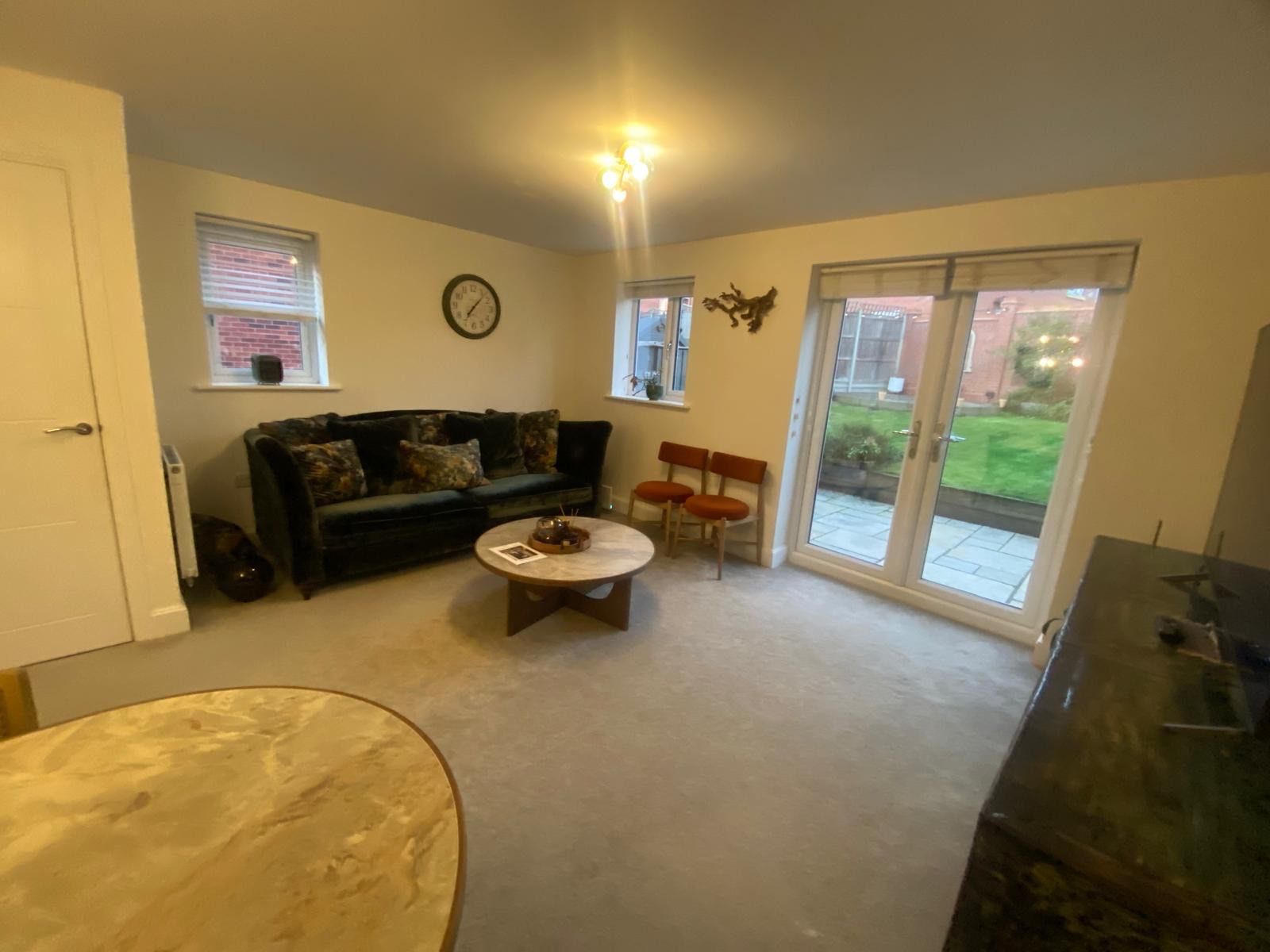 A living room with a sofa, a coffee table, and a television.