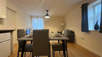 A compact living space with a dining area, kitchenette, and seating area.