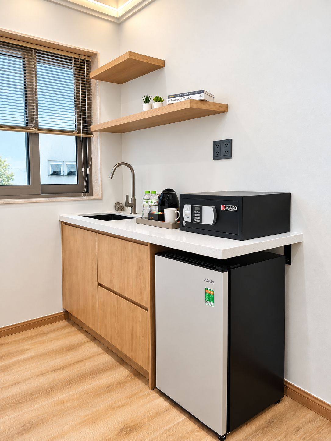 A compact kitchen with a built-in dishwasher, a microwave, a sink, and a window with blinds.