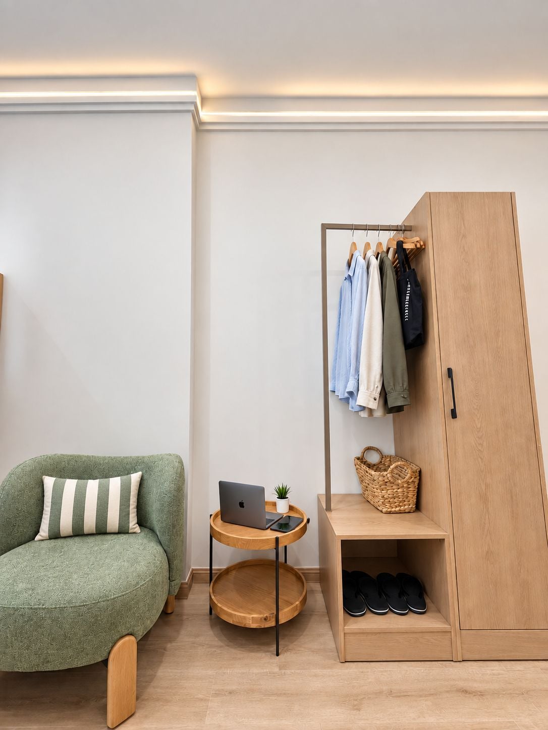 Een kamer met een groene bank, een houten garderobe, een klein houten tafeltje met een laptop en een plant, en een paar schoenen op een plank.