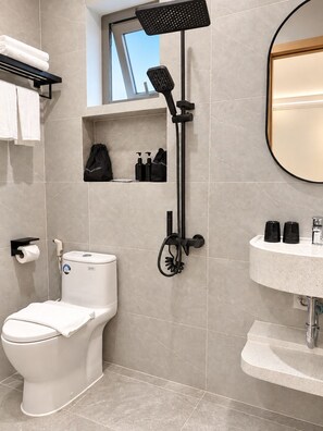Un baño moderno con inodoro, ducha y lavamanos.