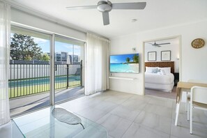 A modern hotel room with a balcony, a bed, a TV, and a dining area. - Couple Escape-10min walk to Hastings St&Beach (Noosa Heads)