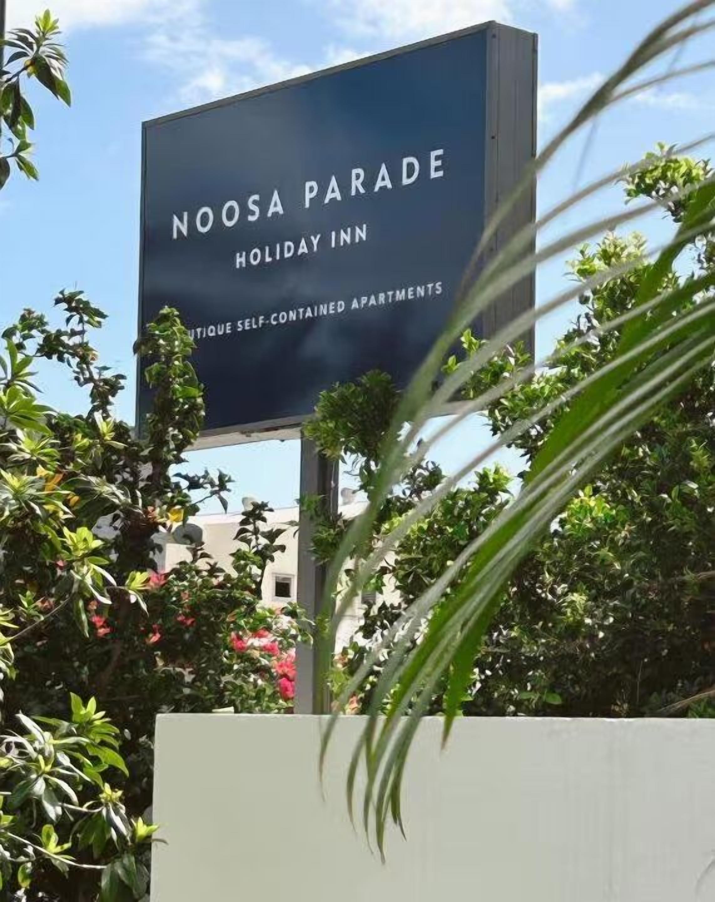 A sign for Noosa Parade Holiday Inn advertising self-contained apartments.