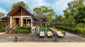A resort with a pool, lounge chairs, and a wooden building with a staircase. - Siritarar Residence by Elite Havens (Lipa Noi)