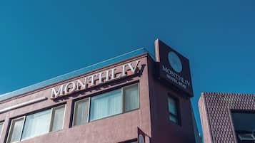 A building with a sign that reads 'MONTHLY HOTEL STAY'.