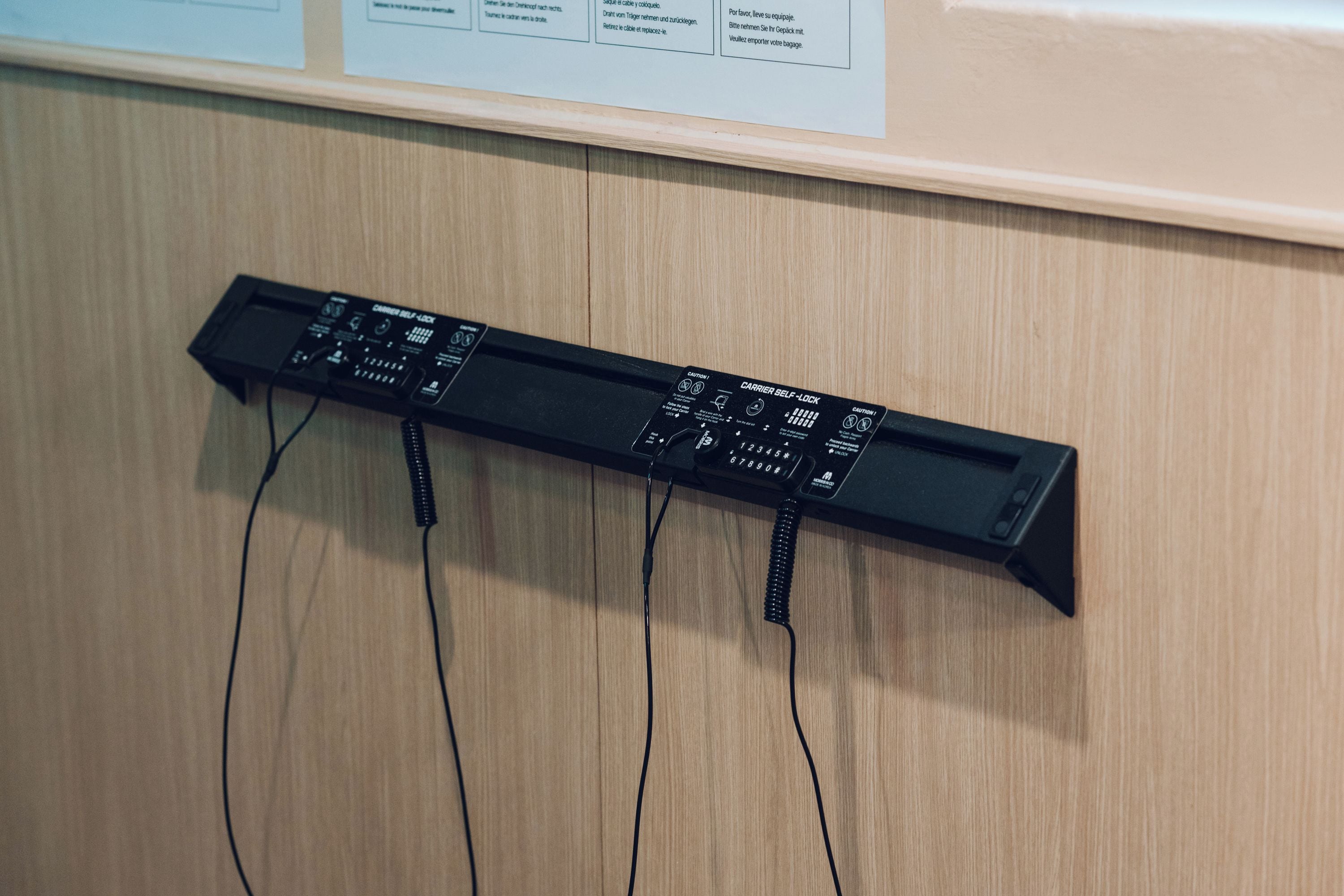 Un dispositivo electrónico negro con varios cables conectados, sobre una superficie de madera.