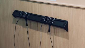 Un dispositivo electrónico negro con varios cables conectados, sobre una superficie de madera.