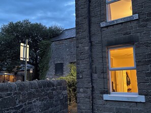 Ein Steinhaus mit einem Fenster, das einen Mantel und eine Tür zeigt.