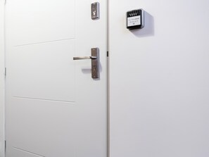 Une porte blanche avec un trou de serrure et une poignée de porte.