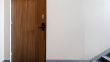 A wooden door with a number '38' above it, a black door handle, and a small electronic lock on the right side.