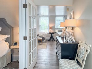 A bedroom with a bed, bedside table, lamp, and decorative items.