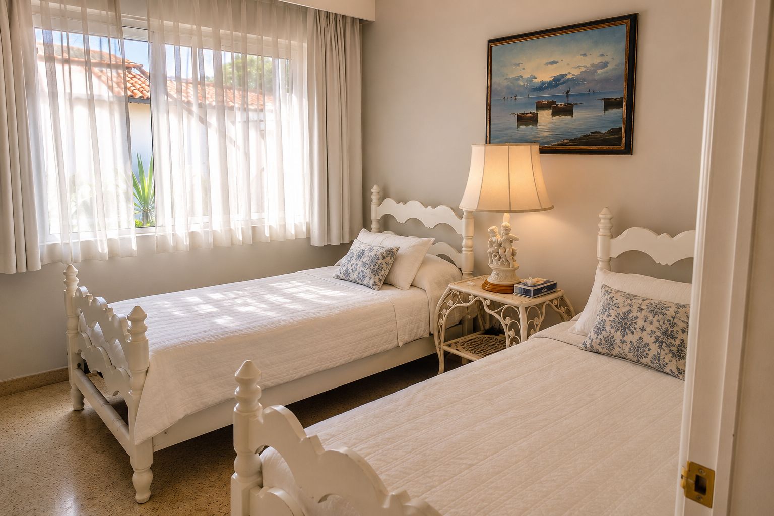 Quarto com duas camas brancas, uma luminária e um quadro na parede.