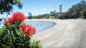 A beach with a clear view of the ocean and a distant city skyline.
