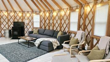 Un intérieur chaleureux avec un canapé, des fauteuils, une table basse et une cheminée.