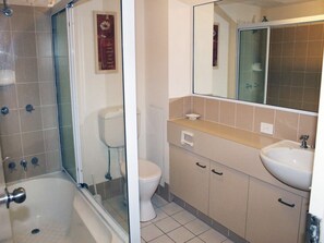 Ein Badezimmer mit Badewanne, Toilette, Waschbecken und Spiegel.
