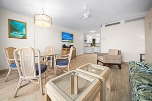 A modern living room with wicker furniture, a glass coffee table, and a flat-screen TV. - Kaanapali Maui Eldorado D103 Garden View 2 BD (Lahaina)